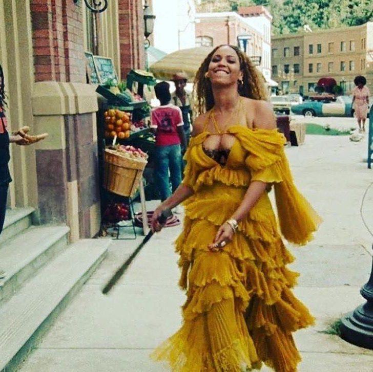 Beyonc%C3%A9+strutting+down+the+road+while+she+sings+%E2%80%9CHold+Up%E2%80%9D+and+breaks+things+like+a+fire+hydrant+%2C+multiple+car+windows%2C+and+a+security+camera+with+a+baseball+bat.+