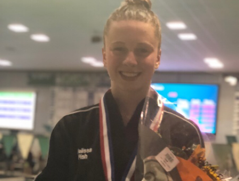 Melissa Pish stands on block one after placing first in the 500 freestyle.