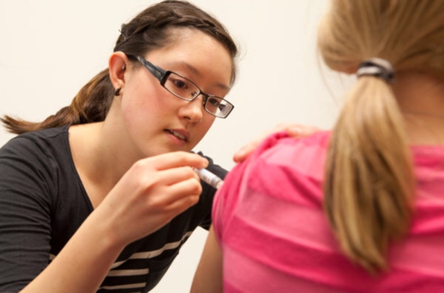 Nursing+Student+at+Queens+University+giving+a+flu+shot.%0D%0A%0D%0APhoto+by+Queens+University